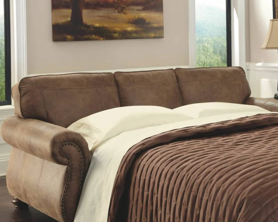 Signature Design by Ashley Larkinhurst Queen Sleeper Sofa in Brown Faux Leather with Nailhead Trim & 2 Decorative Pillows