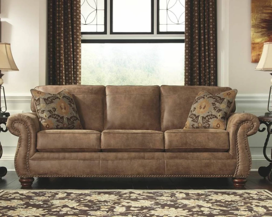 Signature Design by Ashley Larkinhurst Brown Faux Leather Sofa with Nailhead Trim & 2 Accent Pillows
